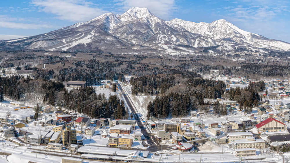 Drone view of Myoko Kogen village from behind the train station